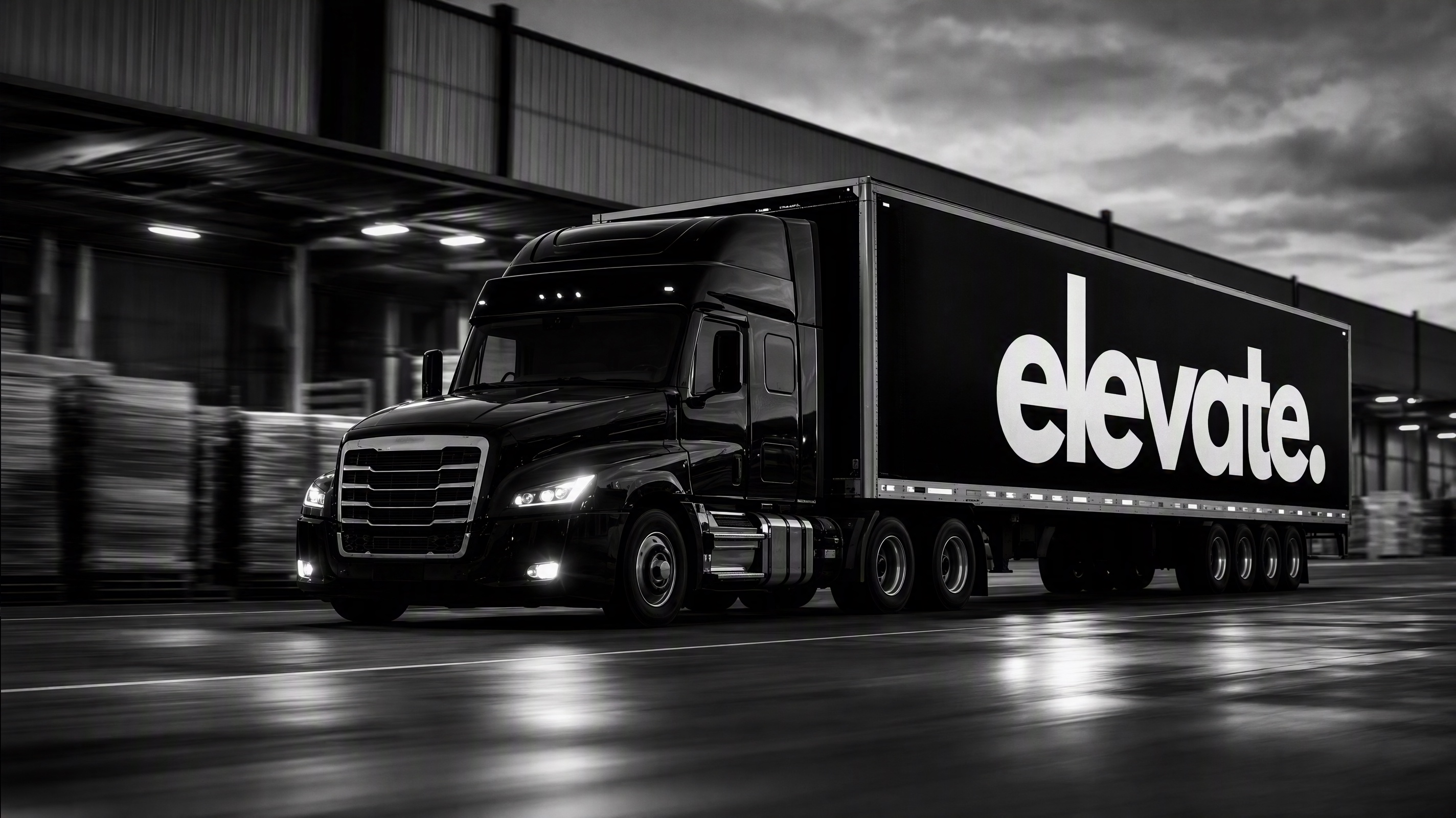 A black ELEVATE-branded logistics truck moving through a modern distribution precinct